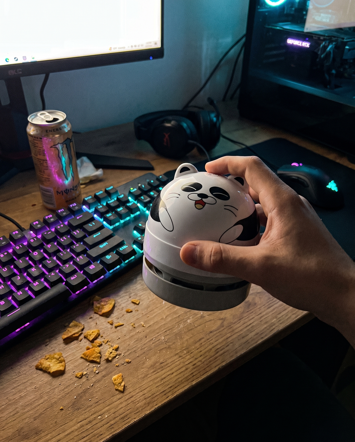 DeskVac Panda – Grau in der Hand neben der RGB-Tastatur